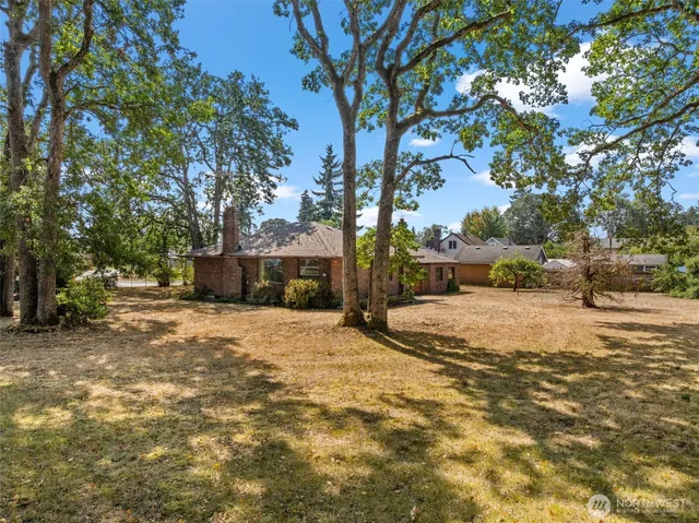 a tall yellow house with trees in front of it