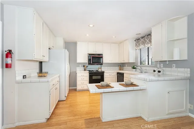 a kitchen with white cabinets appliances and sink