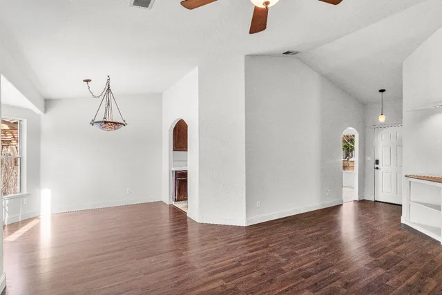 a backyard of a house with table and chairs with wooden fence