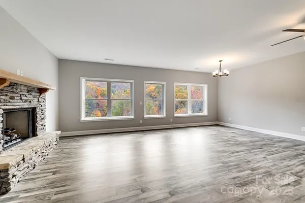 wooden floor fireplace and windows in an empty room