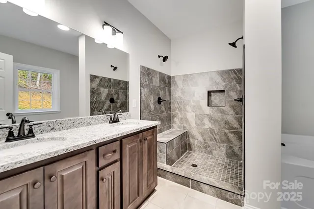 a bathroom with a granite countertop double vanity sink mirror and shower