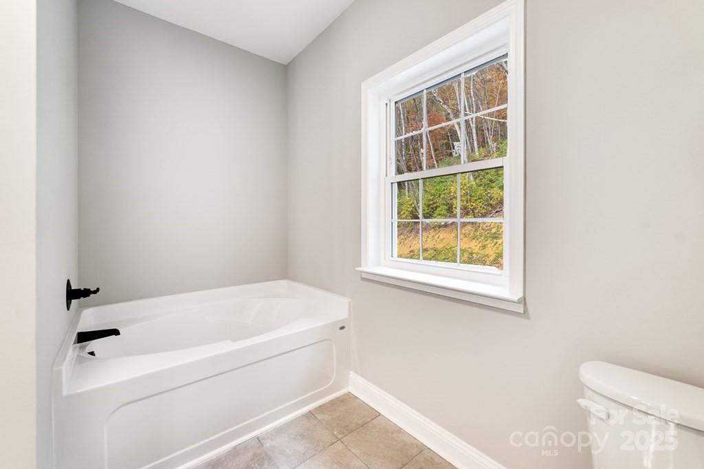 679 Firefly Road Whittier, NC 28789 - Photo 21 of 34 a white bath tub sitting next to a toilet