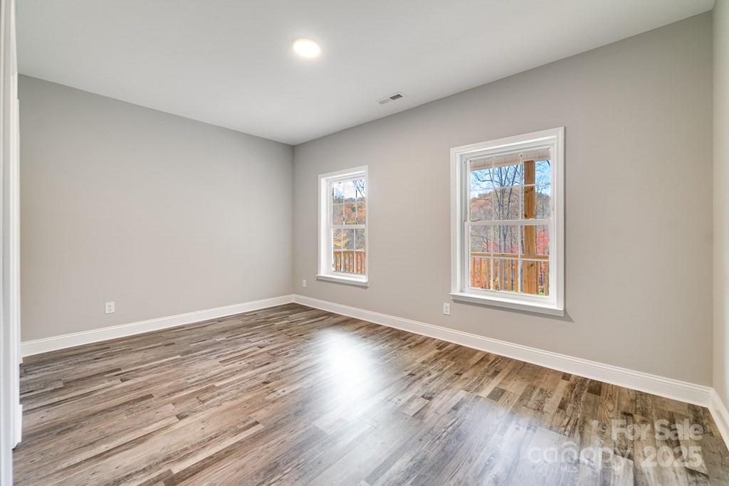 679 Firefly Road Whittier, NC 28789 - Photo 22 of 34 a view of an empty room with wooden floor and a window