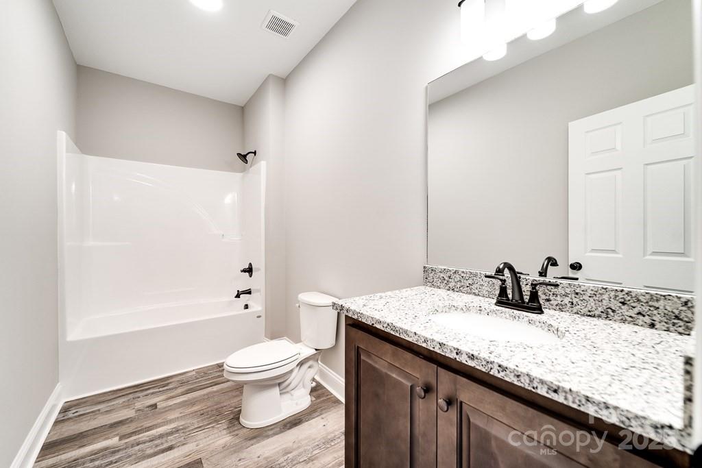 679 Firefly Road Whittier, NC 28789 - Photo 24 of 34 a bathroom with a granite countertop sink a toilet and shower