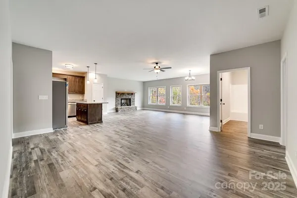 a view of empty room with wooden floor and windows
