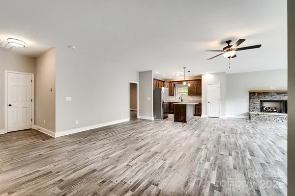 a view of empty room with wooden floor and fireplace