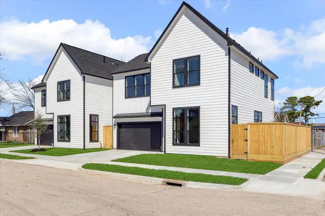 a view of a white house with a yard and a large space