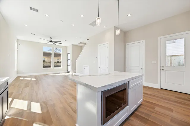 a kitchen with a stove and a wooden floor
