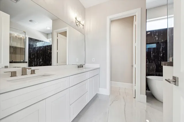 a bathroom with a double vanity sink mirror and shower
