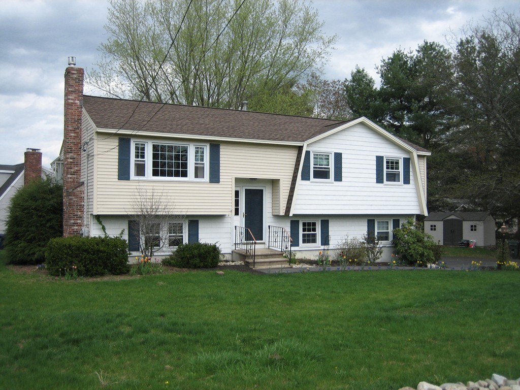 a front view of a house with a yard and green space