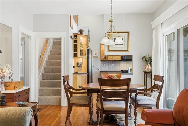 a dining room with furniture a chandelier and wooden floor