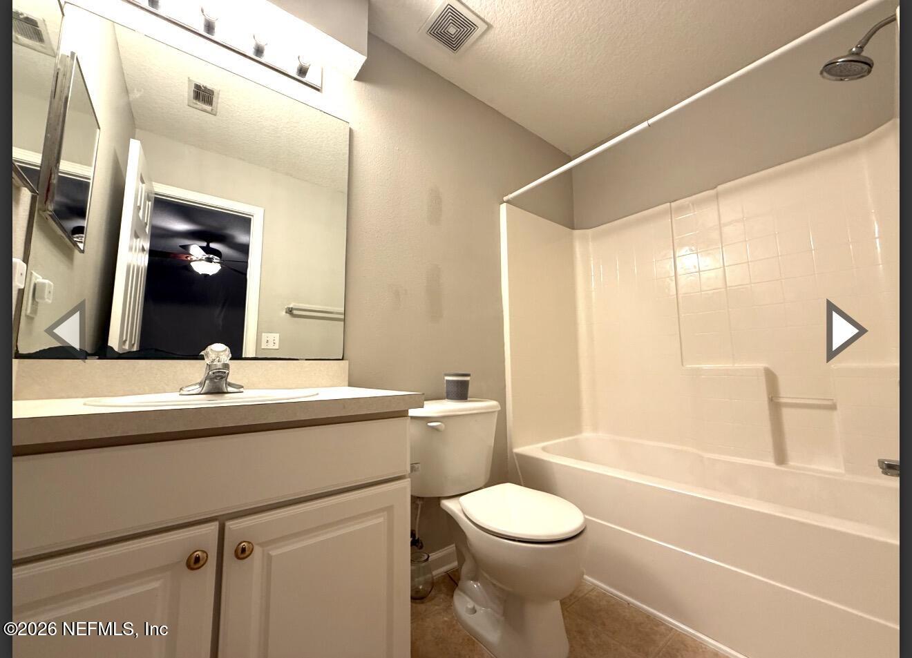 7850 Melvin Road Jacksonville, FL 32210 - Photo 11 of 12 a bathroom with a granite countertop sink a toilet and shower