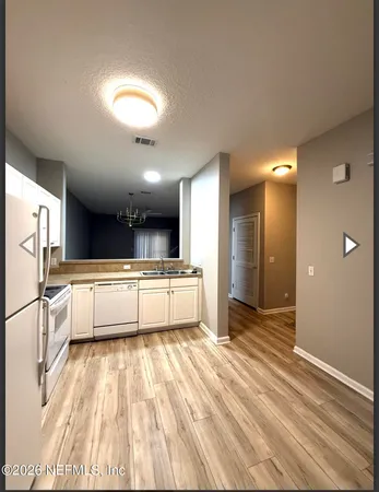 a view of a kitchen with kitchen island a counter top space a sink and stainless steel appliances