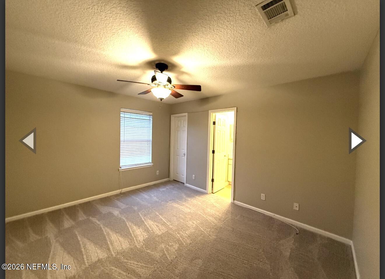7850 Melvin Road Jacksonville, FL 32210 - Photo 8 of 12 a view of an empty room with a chandelier fan and a window
