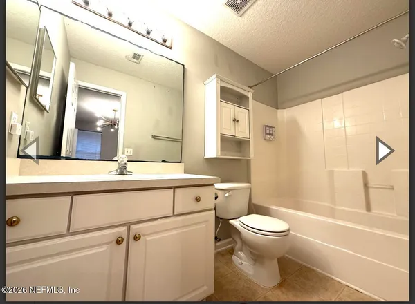a bathroom with a sink a toilet and a large mirror