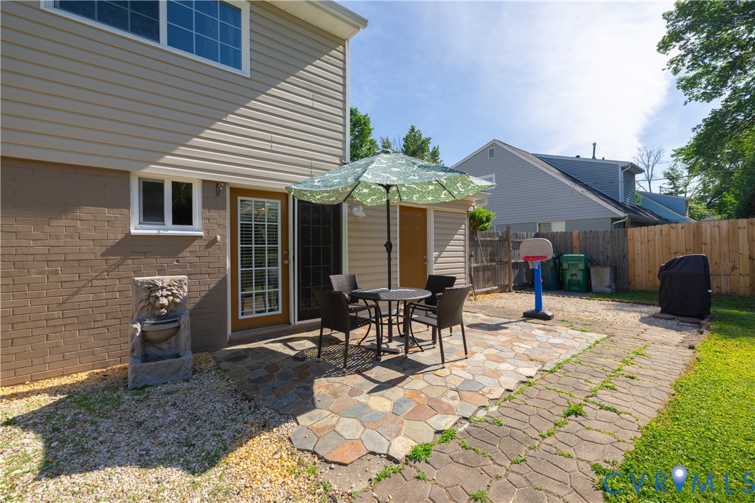 9217 Fisk Road Richmond, VA 23229 - Photo 30 of 39 a view of a patio with table and chairs under an umbrella