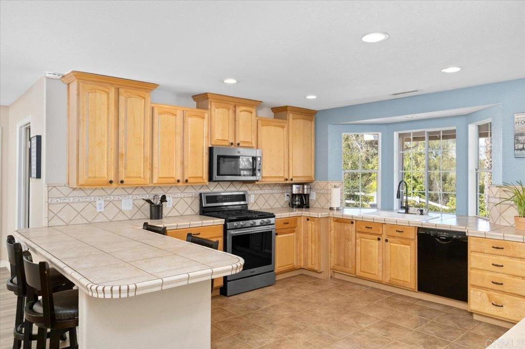 30405 Del Rey Road Temecula, CA 92591 - Photo 10 of 46 a kitchen with a stove a sink a microwave a counter top space and cabinets