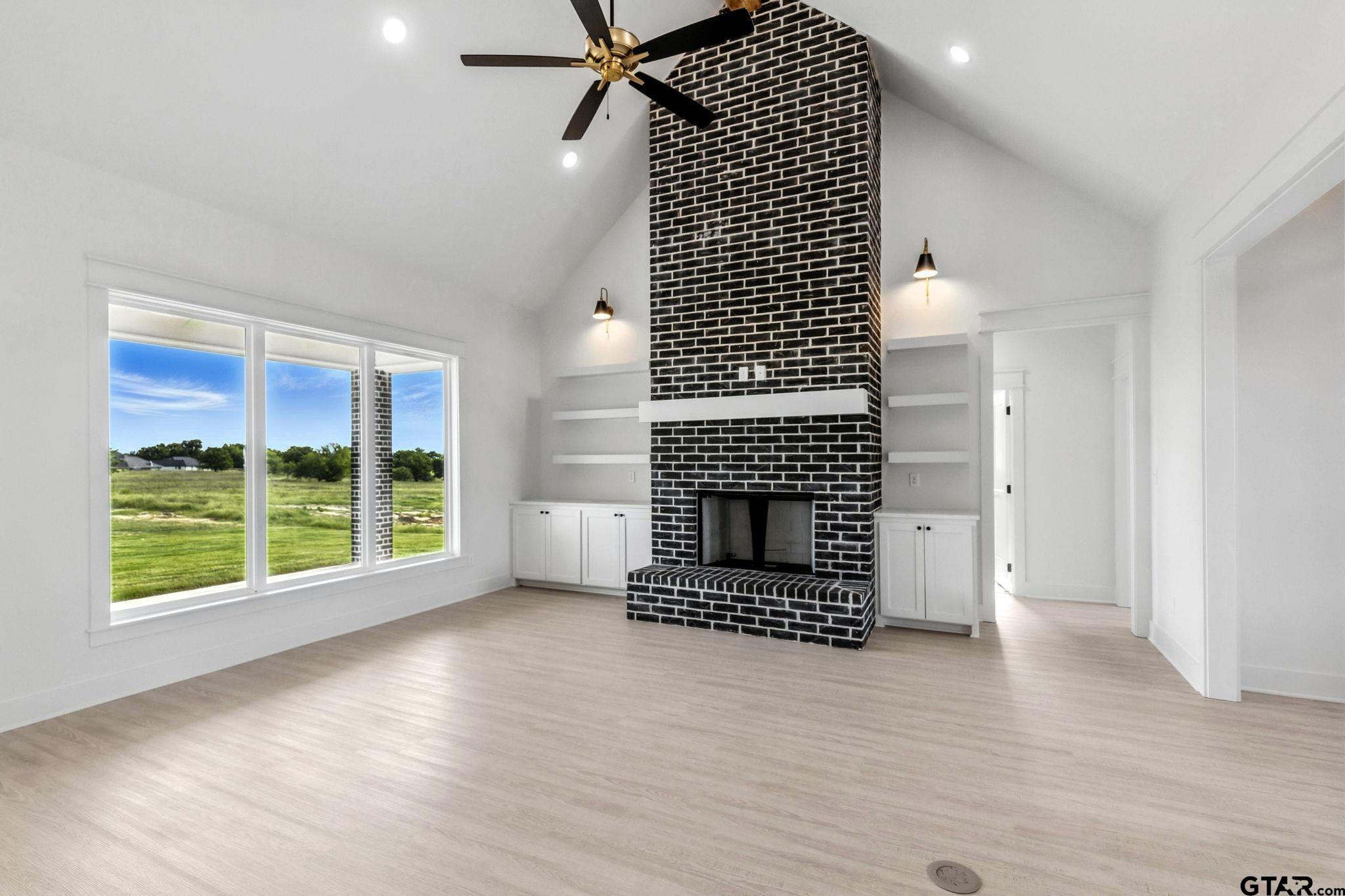 15524 County Road 434 Lindale, TX 75771 - Photo 10 of 23 an empty room with wooden floor a fireplace and windows