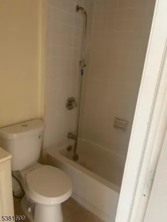 a white toilet sitting next to a bath tub