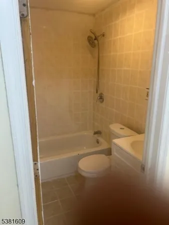 a bathroom with a granite countertop bathtub shower and toilet