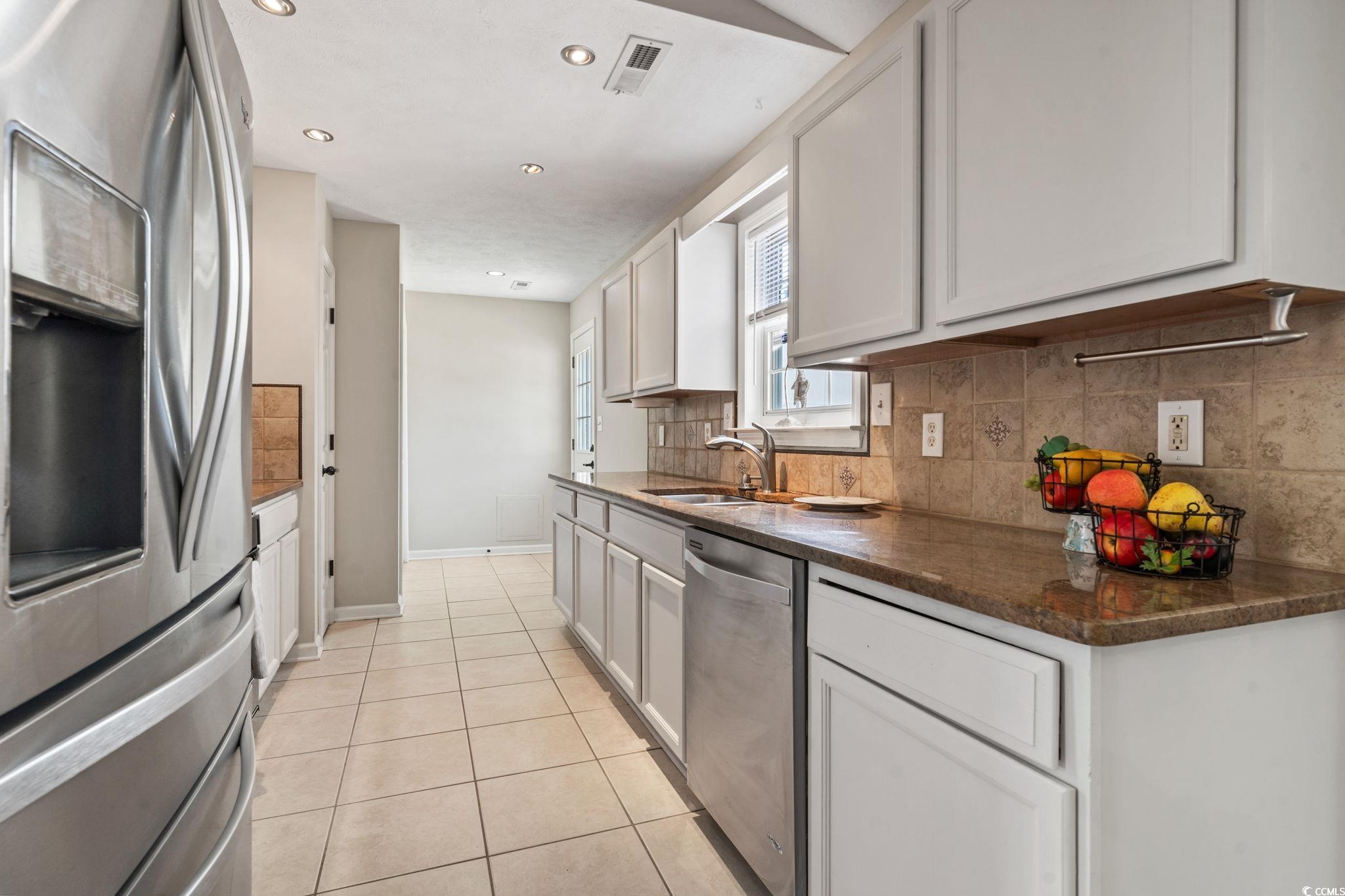 1007 Autumn Drive Murrells Inlet, SC 29576 - Photo 13 of 33 Kitchen featuring appliances with stainless steel finishes, backsplash, light tile patterned flooring, white cabinets, and recessed lighting