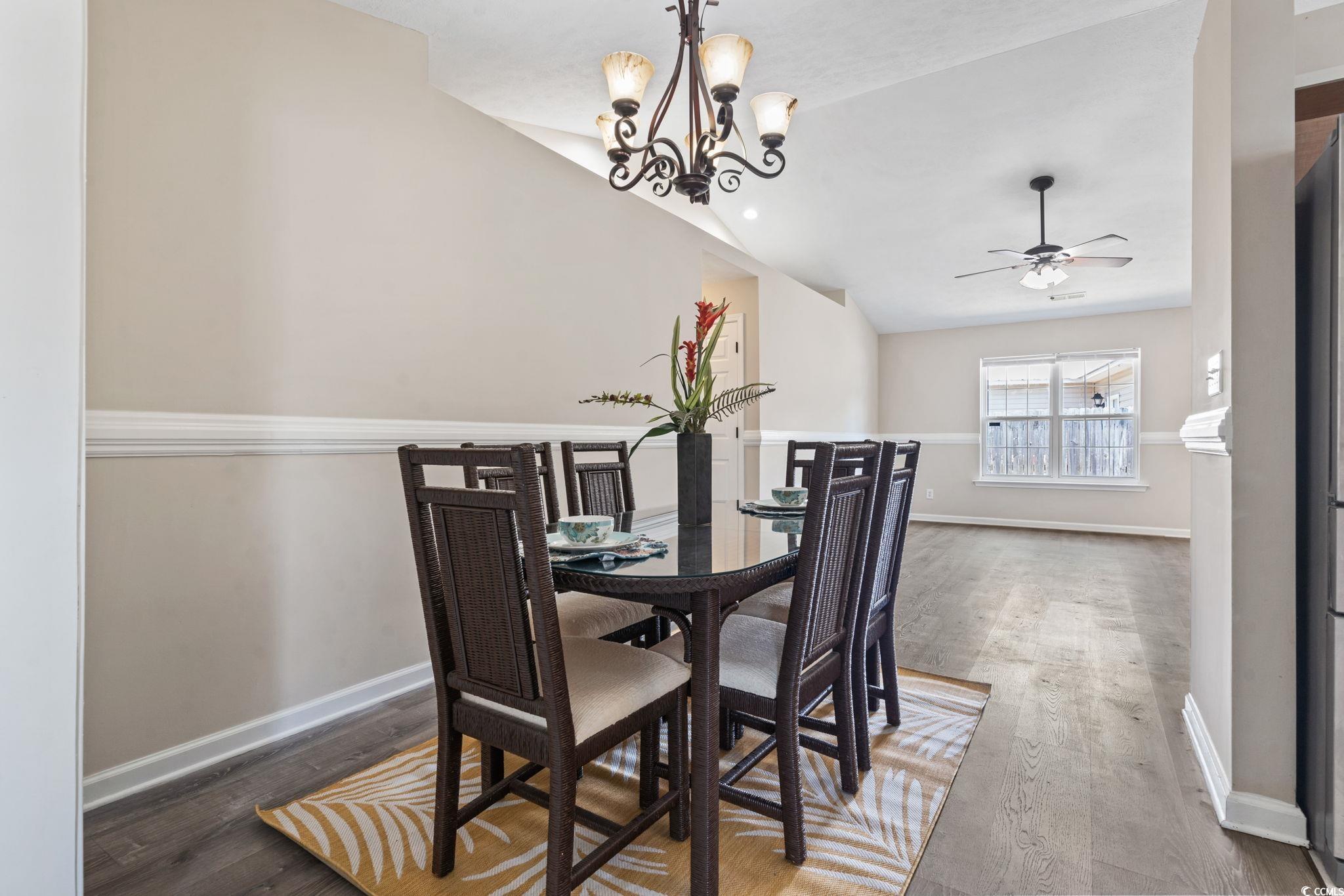 1007 Autumn Drive Murrells Inlet, SC 29576 - Photo 9 of 33 Dining space with vaulted ceiling, wood finished floors, a ceiling fan, and a chandelier