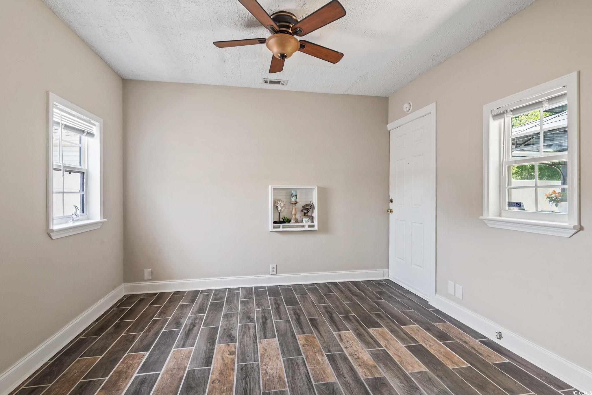 1007 Autumn Drive Murrells Inlet, SC 29576 - Photo 10 of 33 Spare room with dark wood-style flooring, a ceiling fan, and a textured ceiling