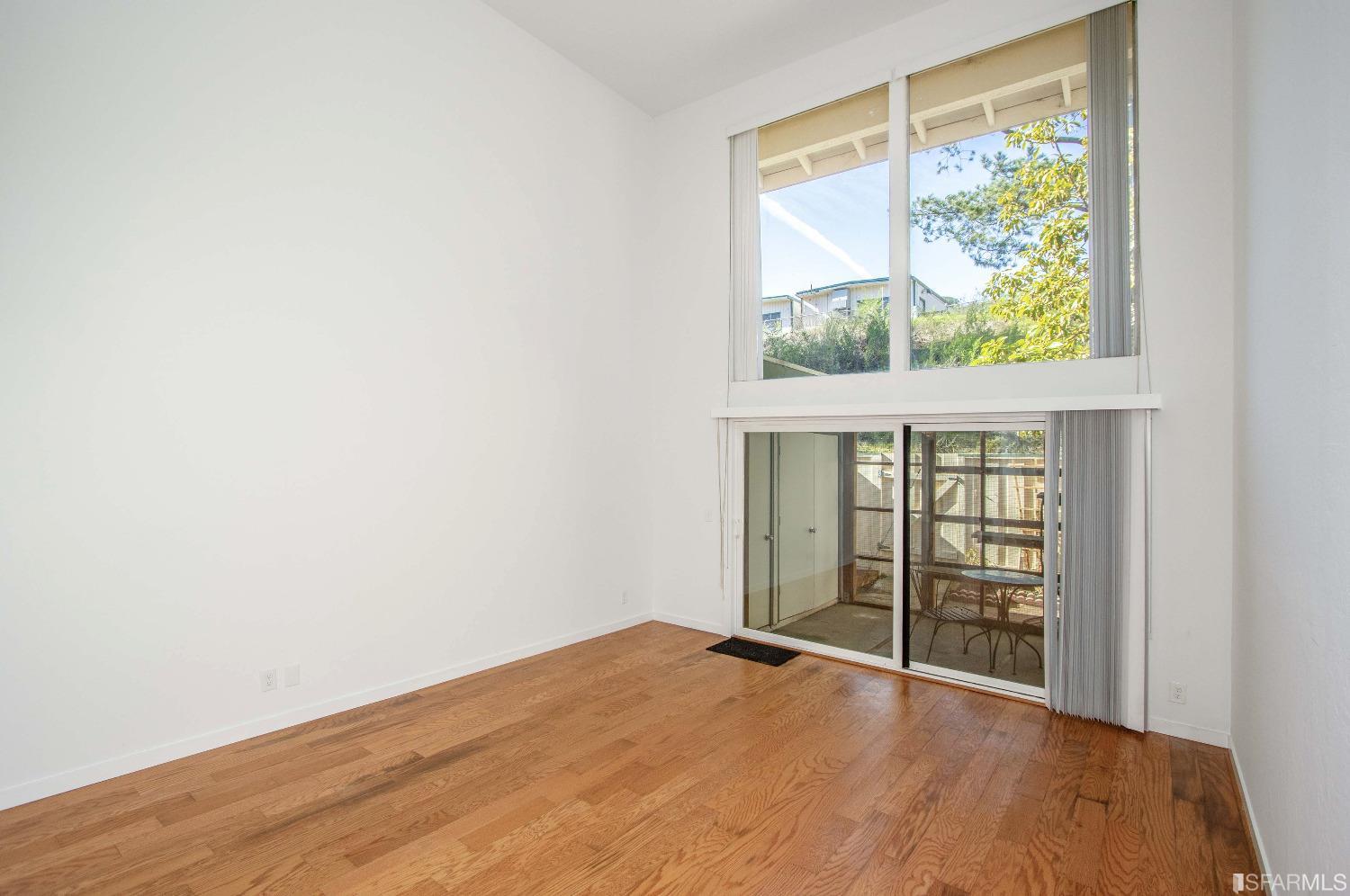 1253 Terra Nova Boulevard Pacifica, CA 94044 - Photo 1 of 23 an empty room with wooden floor and windows