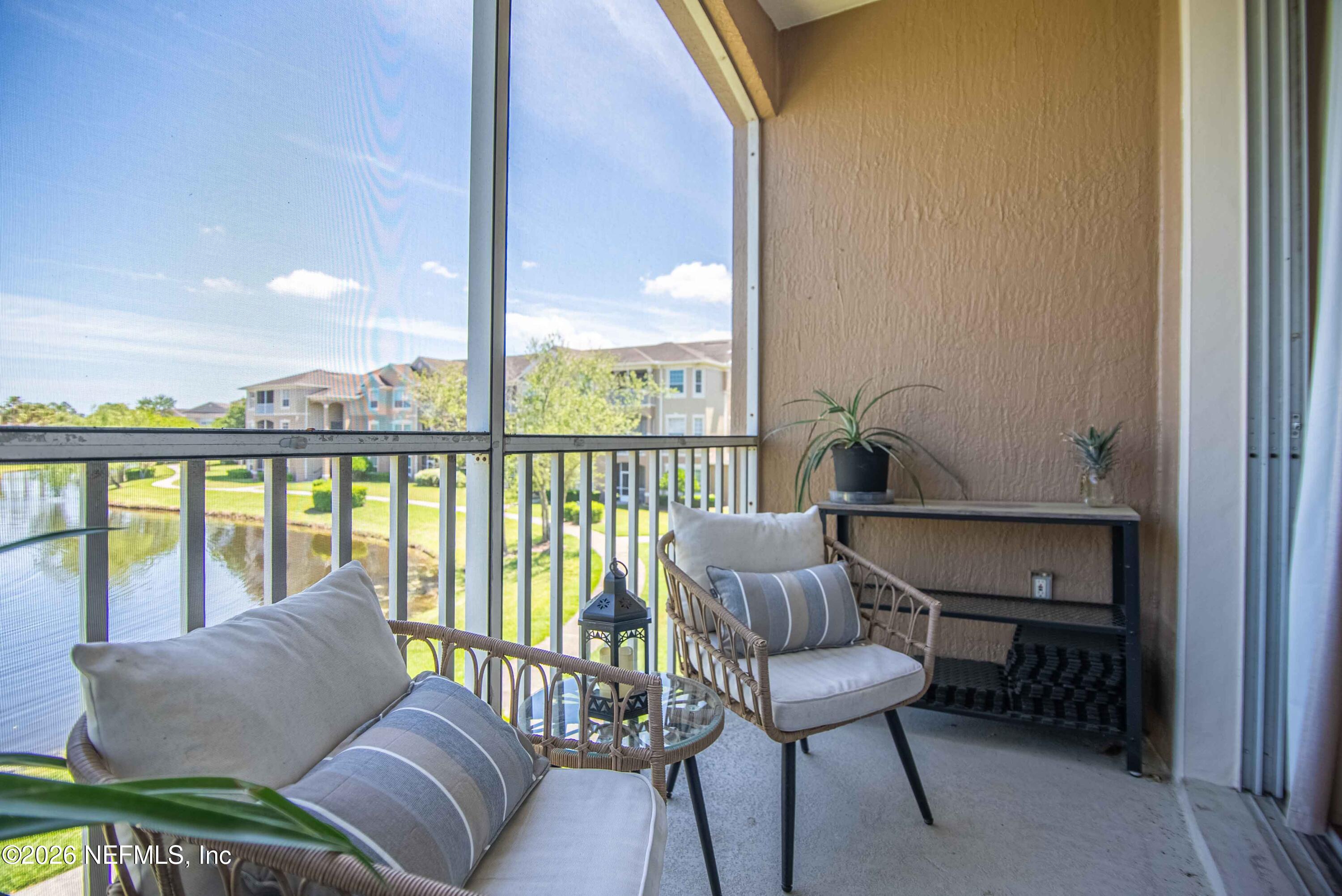 7990 Baymeadows Road East, Unit 823 Jacksonville, FL 32256 - Photo 30 of 45 a living room with furniture and a floor to ceiling window