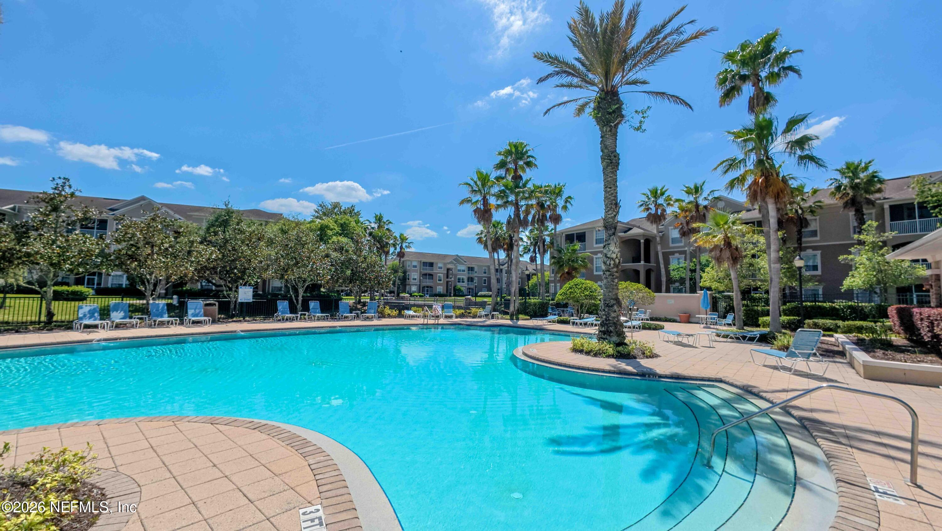 7990 Baymeadows Road East, Unit 823 Jacksonville, FL 32256 - Photo 39 of 45 a view of a swimming pool with a table and chairs