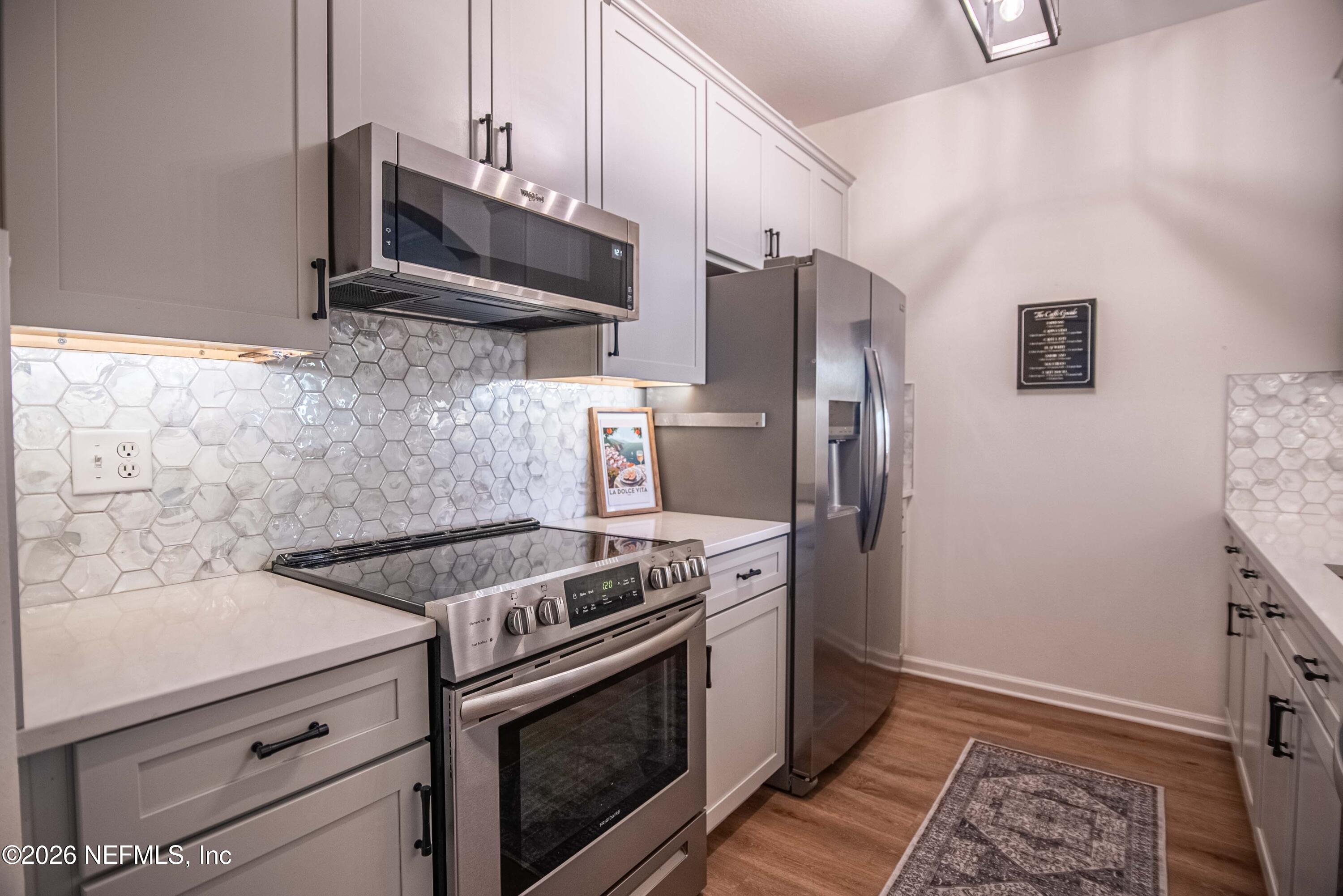 7990 Baymeadows Road East, Unit 823 Jacksonville, FL 32256 - Photo 7 of 45 a kitchen with stainless steel appliances a stove a microwave and a refrigerator
