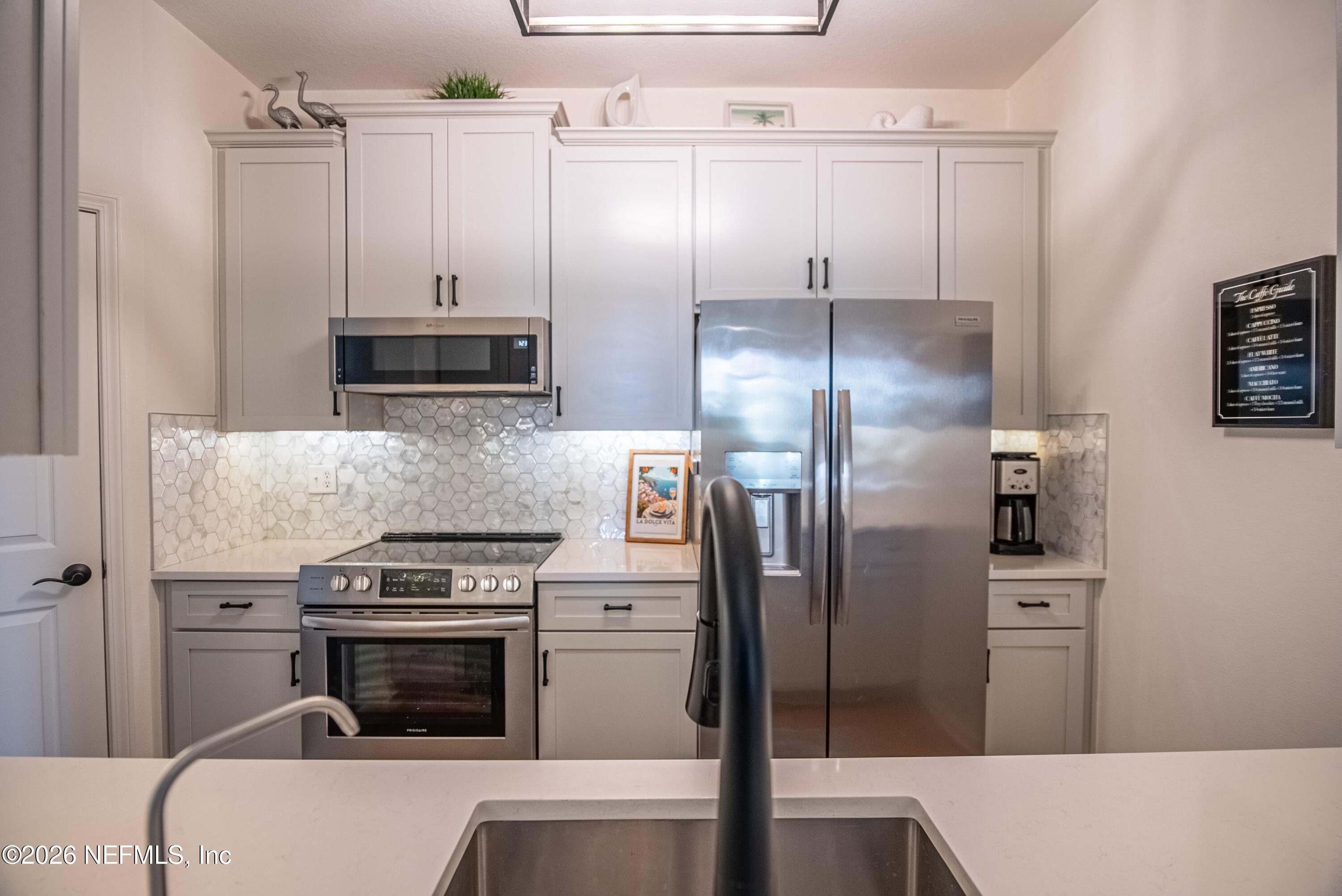 7990 Baymeadows Road East, Unit 823 Jacksonville, FL 32256 - Photo 9 of 45 a kitchen with cabinets and stainless steel appliances