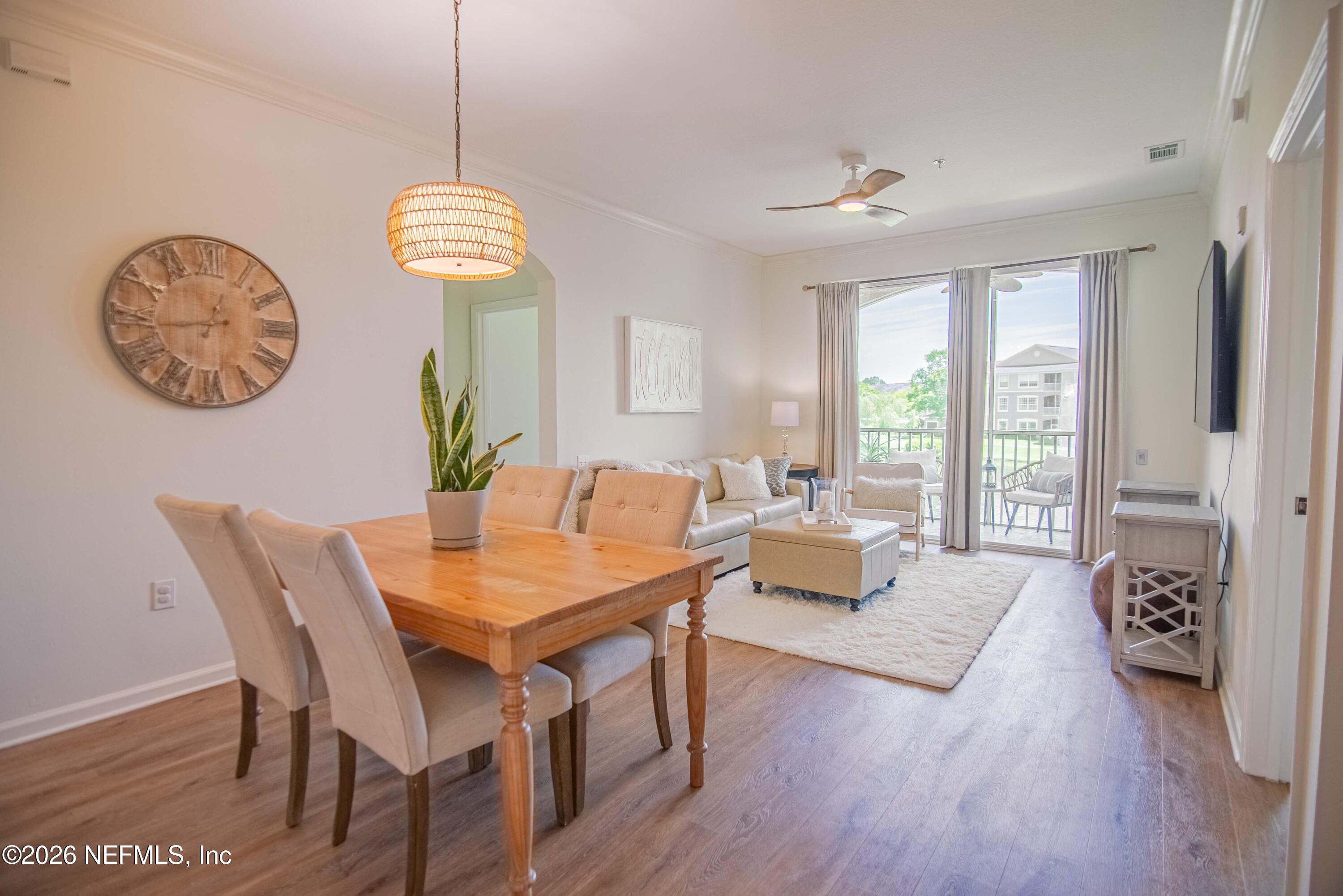 7990 Baymeadows Road East, Unit 823 Jacksonville, FL 32256 - Photo 10 of 45 a view of a dining room with furniture wooden floor and a chandelier