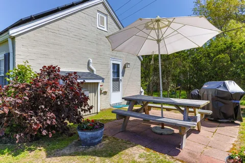 a view of a patio with a table and chairs under an umbrella