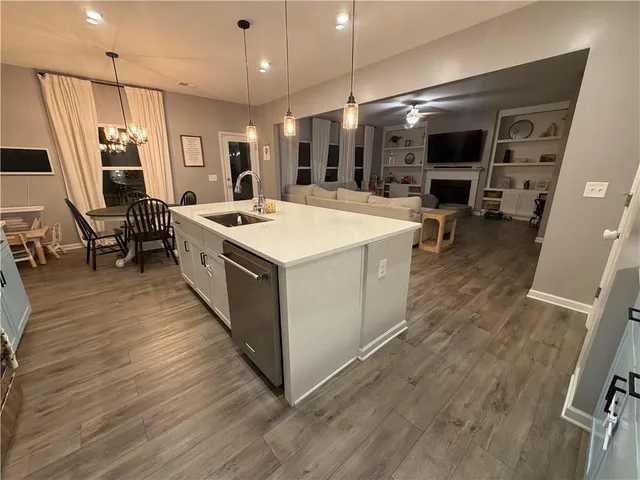 a large kitchen with stainless steel appliances a large counter top a stove a chimney a sink and floors