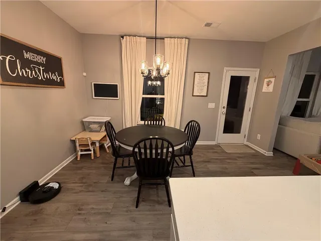 a living room with furniture a flat screen tv and a refrigerator