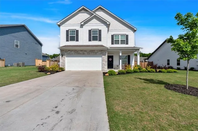 a front view of a house with a yard and trees