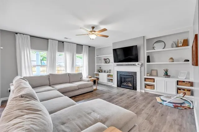 a living room with furniture a fireplace and a flat screen tv