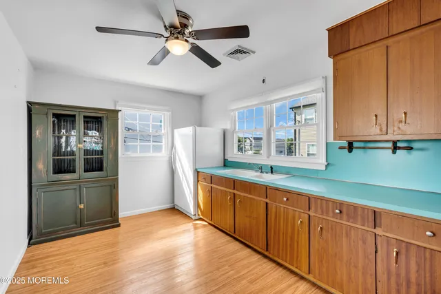 a kitchen with stainless steel appliances granite countertop a refrigerator a sink and dishwasher with wooden floor