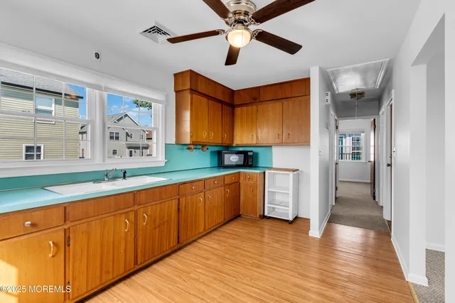 a large kitchen with stainless steel appliances granite countertop a lot of counter space and wooden floors