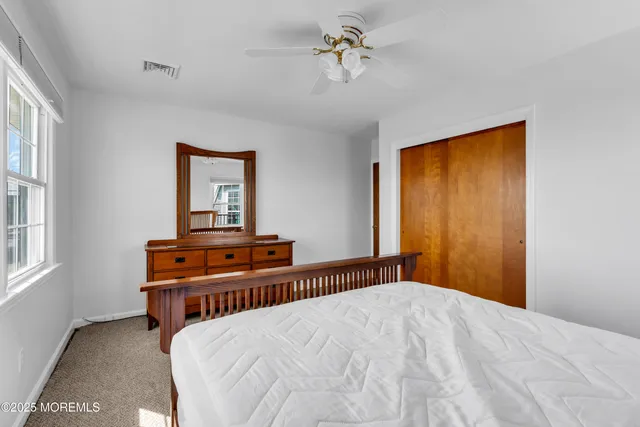 a view of an empty room with closet and a window