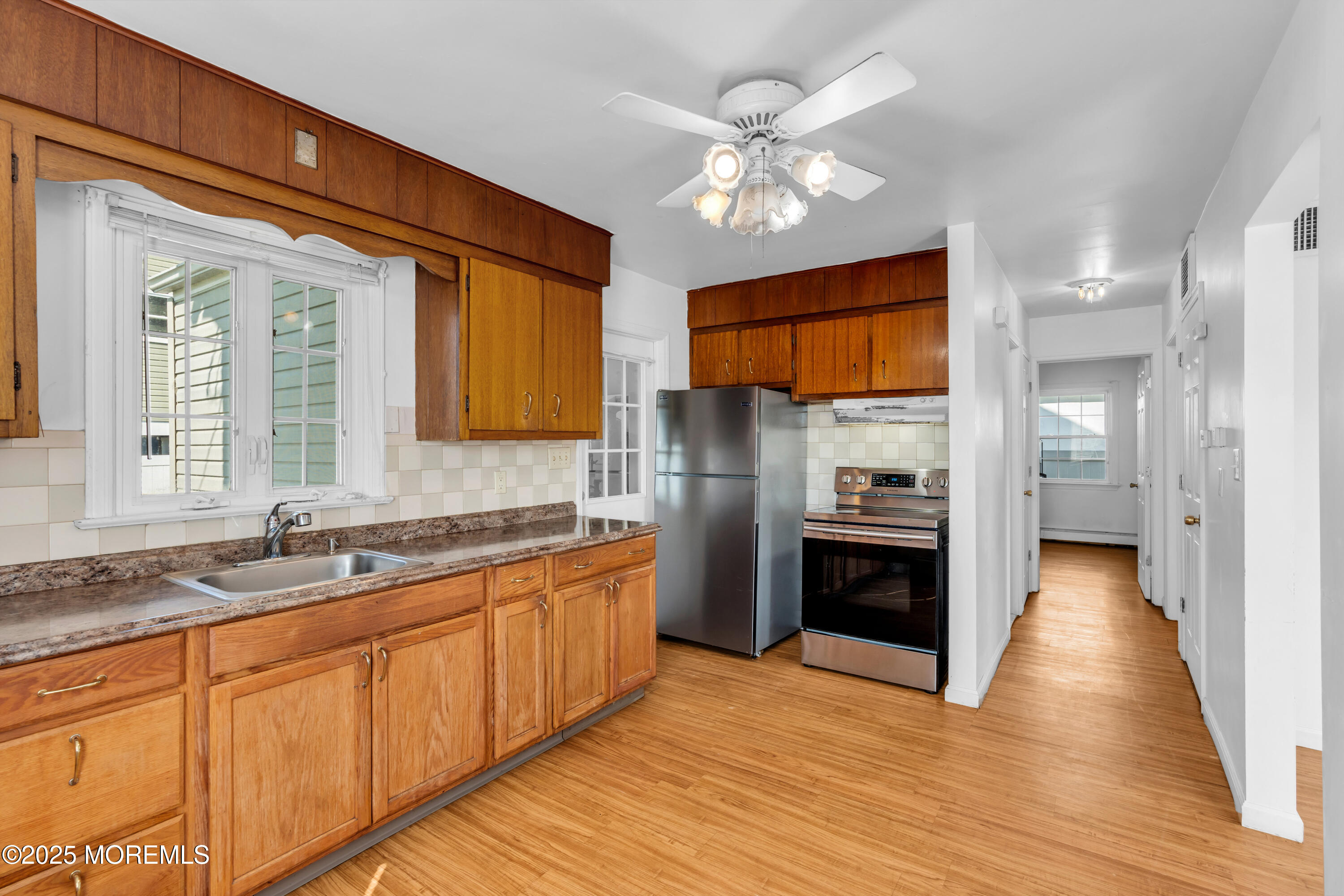 538 Front Street Union Beach, NJ 07735 - Photo 9 of 46 a kitchen with stainless steel appliances granite countertop a refrigerator a sink dishwasher a stove and white countertops with wooden floor