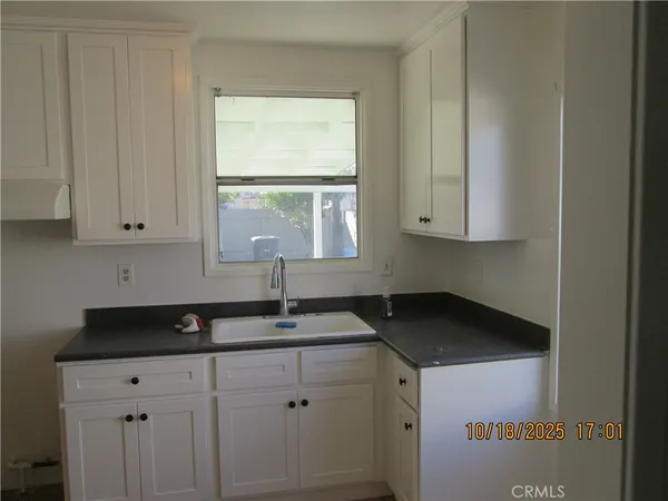 a view of a hallway with wooden floor and a bathroom