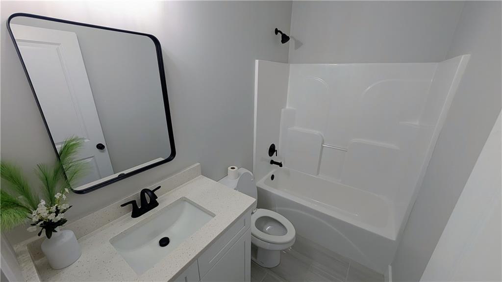 1706 Cunningham Road Southwest Marietta, GA 30008 - Photo 15 of 27 a bathroom with a sink a toilet and a mirror