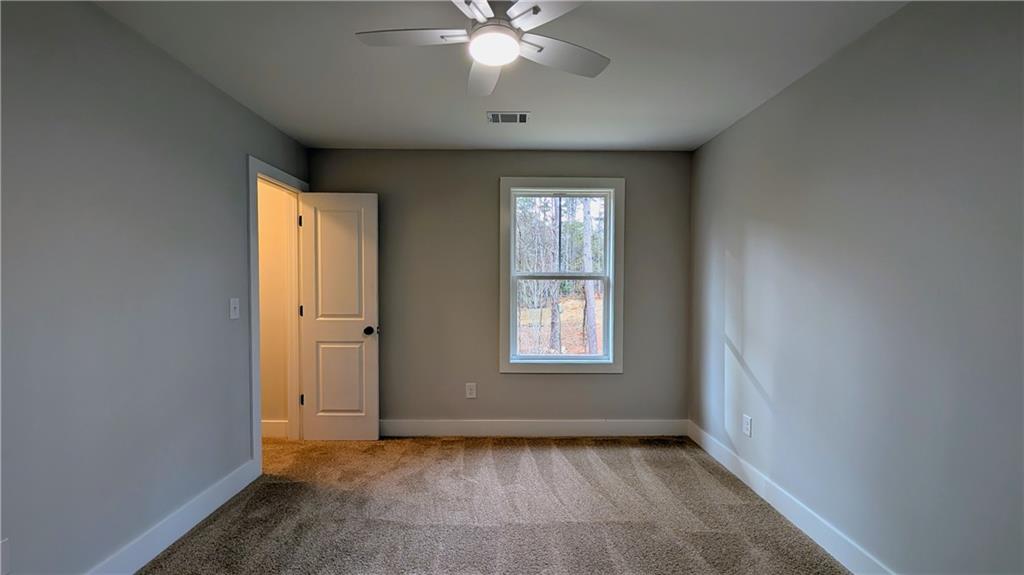1706 Cunningham Road Southwest Marietta, GA 30008 - Photo 18 of 27 an empty room with chandelier fan and windows