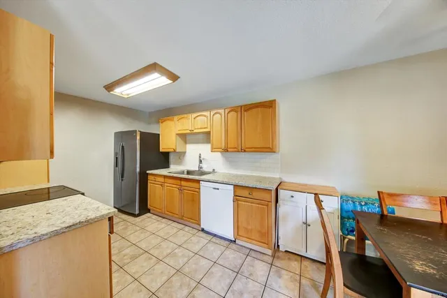 a kitchen with stainless steel appliances granite countertop a sink a stove and a wooden cabinets