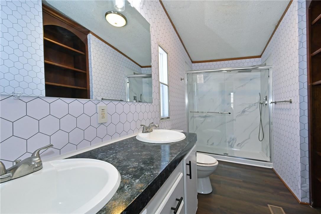 1524-l R L R Schronce Lane Iron Station, NC 28080 - Photo 19 of 32 a bathroom with a granite countertop sink a toilet and shower