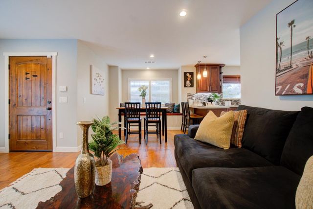 a living room with furniture a dining table and a refrigerator