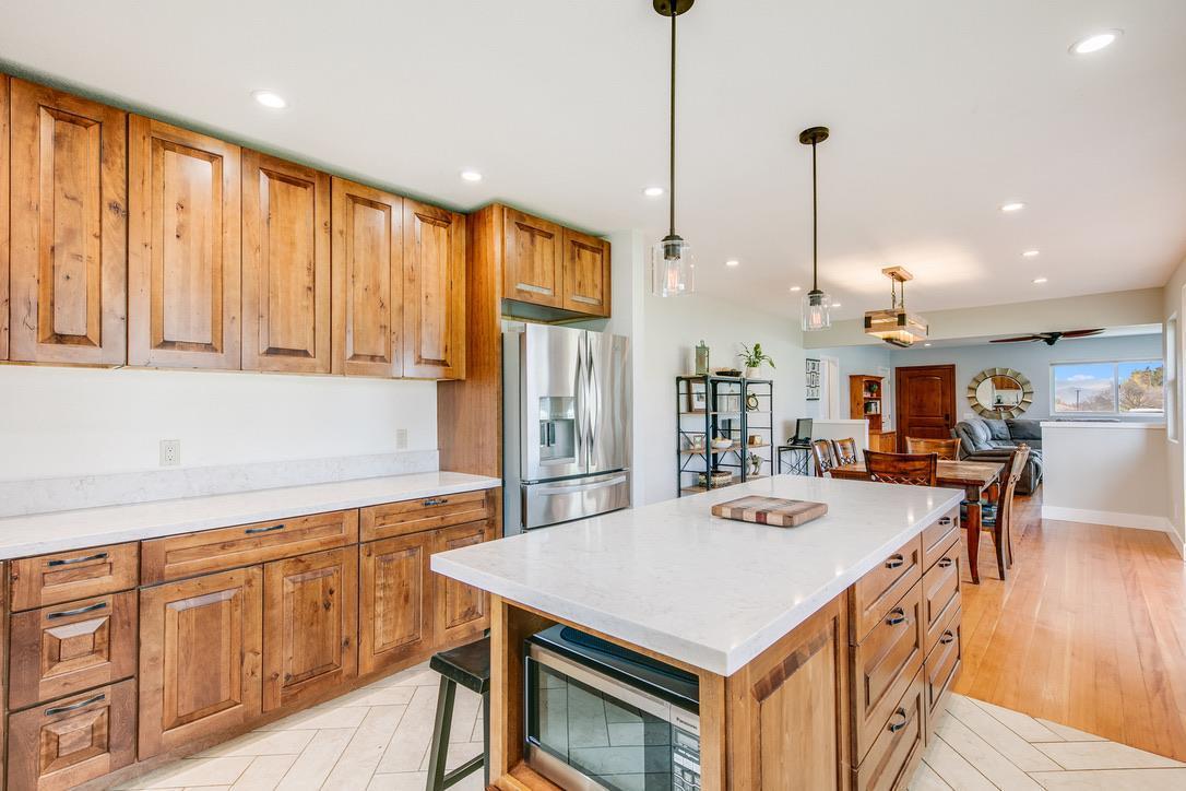 2015 Trumar Lane Gilroy, CA 95020 - Photo 9 of 30 a kitchen with stainless steel appliances granite countertop a stove a refrigerator a kitchen island a island a stove and a wooden floor