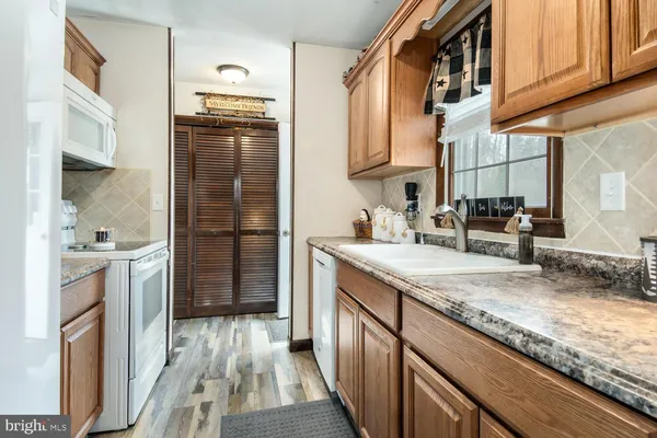 a kitchen with stainless steel appliances granite countertop a refrigerator a stove and a sink with cabinets